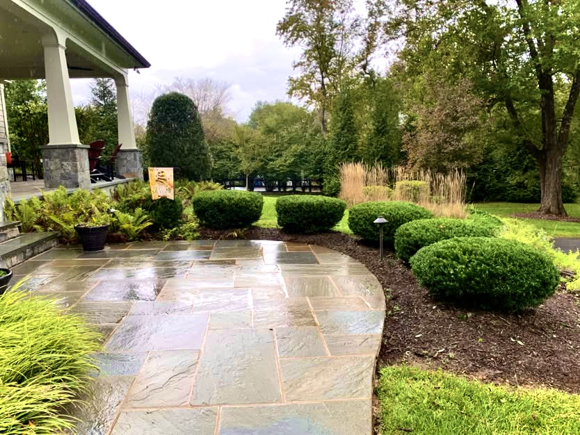 Stone patio beside landscaped shrubs